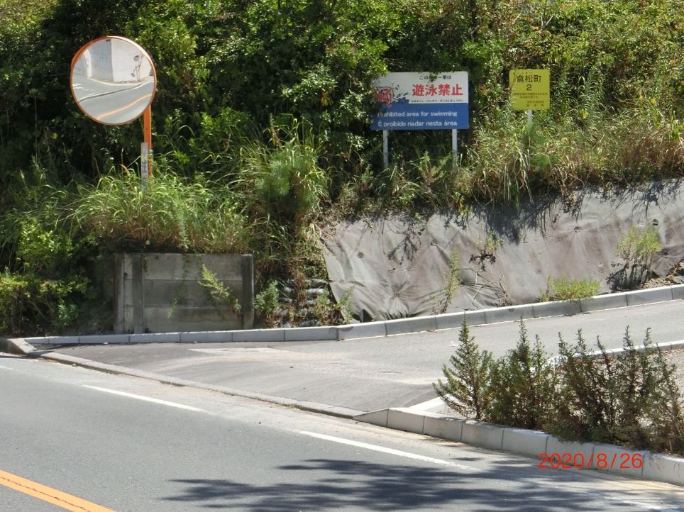 倉松海岸の駐車場出入口です。「倉松町」の黄色の看板があります。